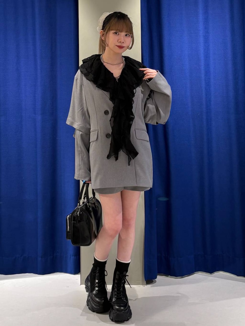 ブラック系のブーツ、ホワイト系のキャミソール、ブラック系のショルダーバッグを着用したレディースの春コーディネートの1枚目の写真