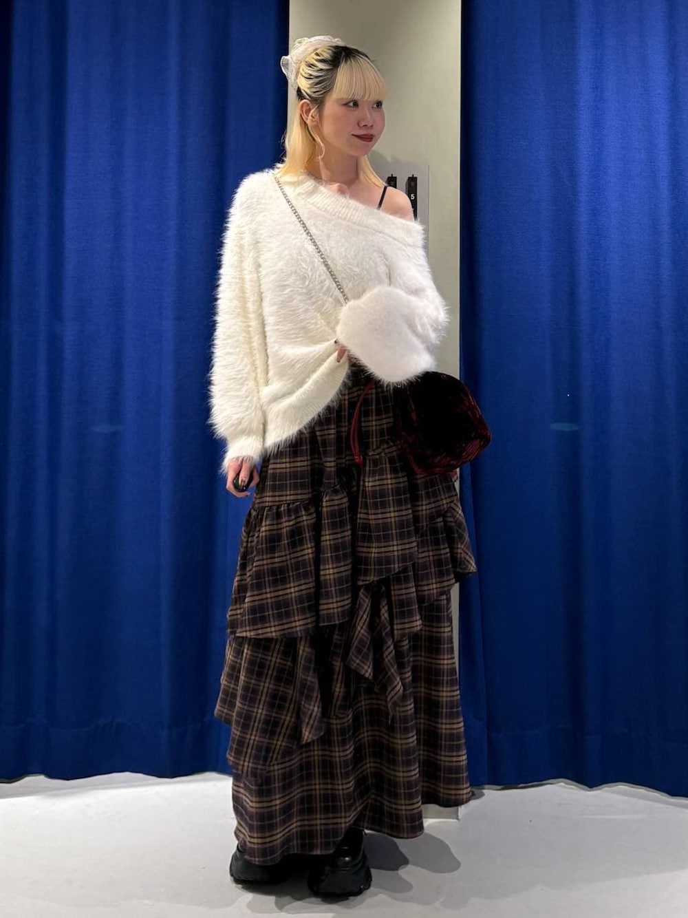 ブラック系のブーツ、ブラウン系のスカート、ホワイト系のニット/セーターを着用したレディースの冬コーディネートの1枚目の写真