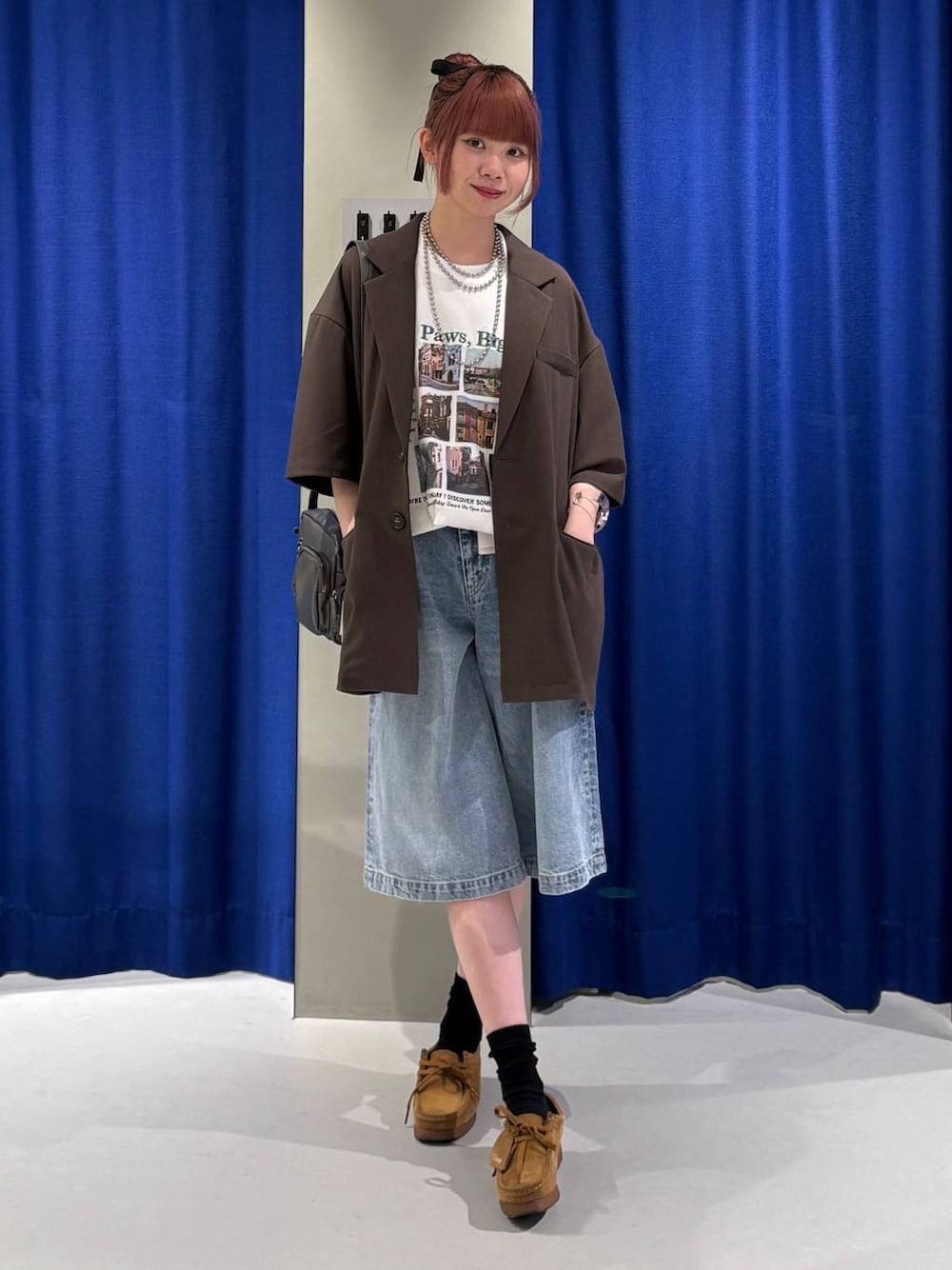 ブルー系のデニムパンツ、グレー系のショルダーバッグ、ホワイト系のTシャツ/カットソーを着用したレディースの春コーディネートの1枚目の写真