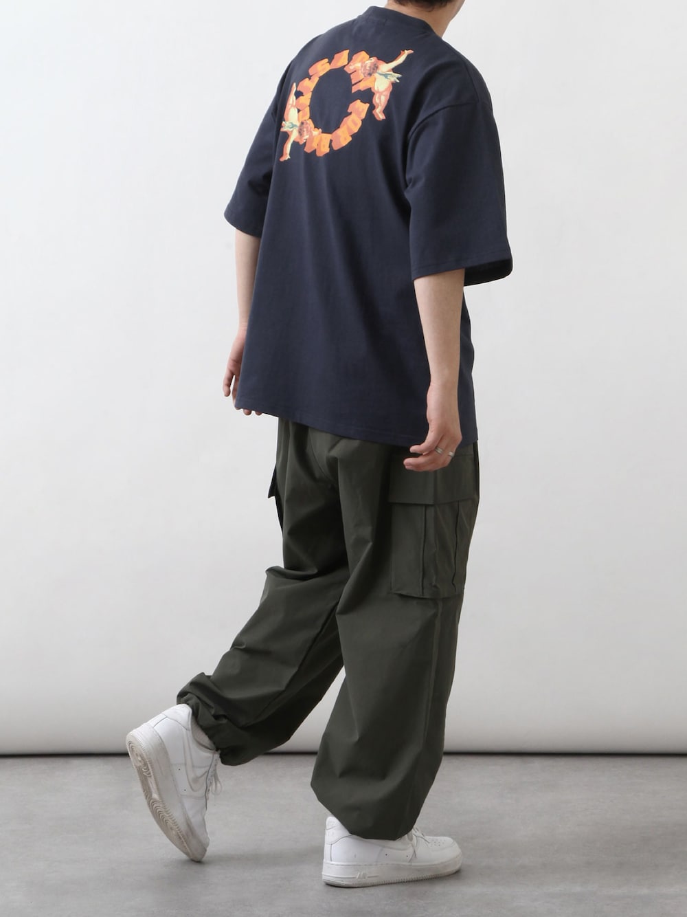 ブルー系のTシャツ/カットソー、グリーン系のカーゴパンツ、ホワイト系のスニーカーを着用したメンズの春コーディネートの1枚目の写真