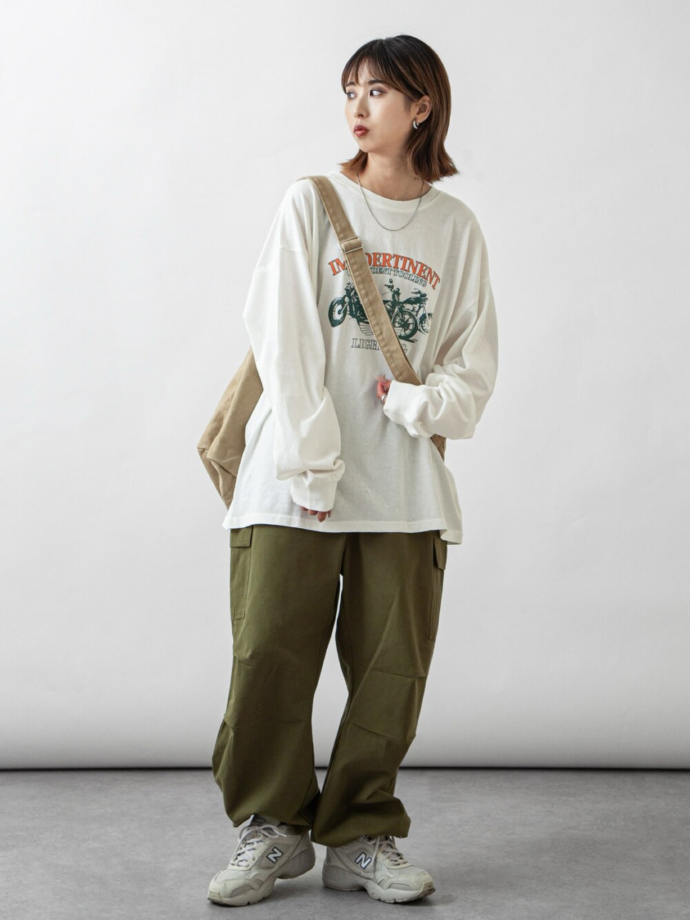 ホワイト系のTシャツ/カットソー、グリーン系のカーゴパンツを着用したレディースの春コーディネートの1枚目の写真