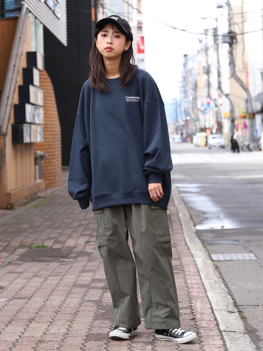 ブルー系のスウェット、グリーン系のカーゴパンツ、ブラック系のスニーカーを着用したレディースの冬コーディネートの1枚目の写真