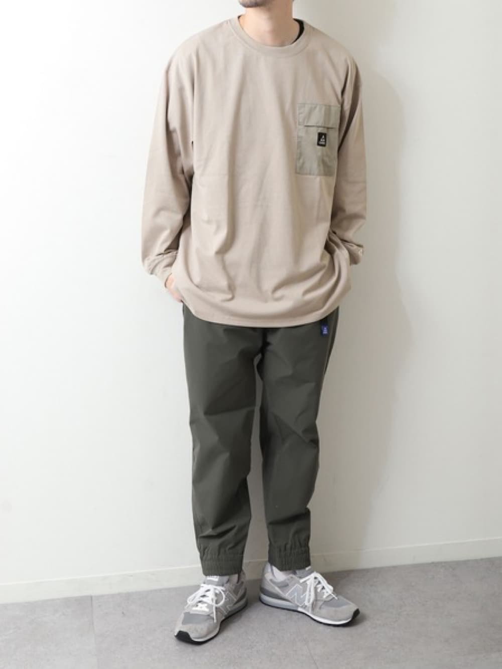 ベージュ系のTシャツ/カットソー、グリーン系のその他パンツ、グレー系のスニーカーを着用したメンズの春コーディネートの1枚目の写真
