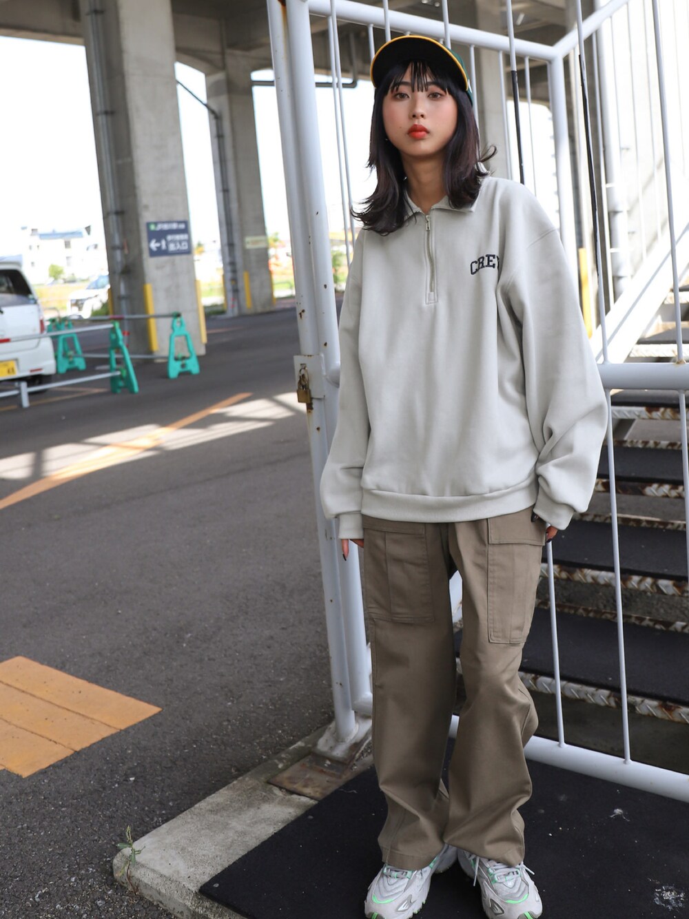 グレー系のスウェット、グリーン系のカーゴパンツ、グレー系のスニーカーを着用したレディースの秋コーディネートの1枚目の写真