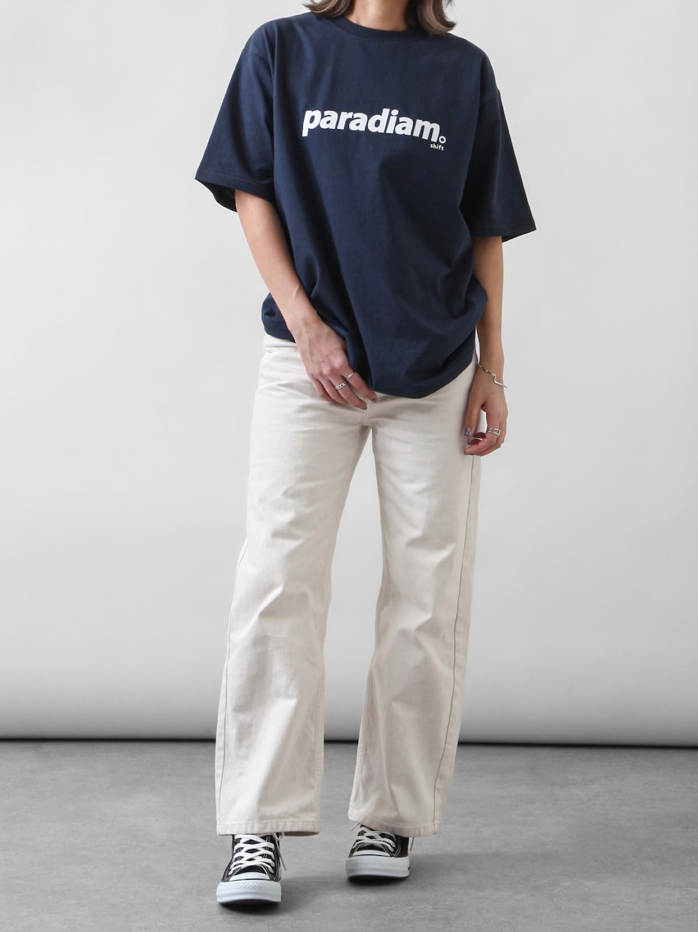 ブルー系のTシャツ/カットソー、ホワイト系のチノパンツ、ブラック系のスニーカーを着用したレディースの春コーディネートの1枚目の写真