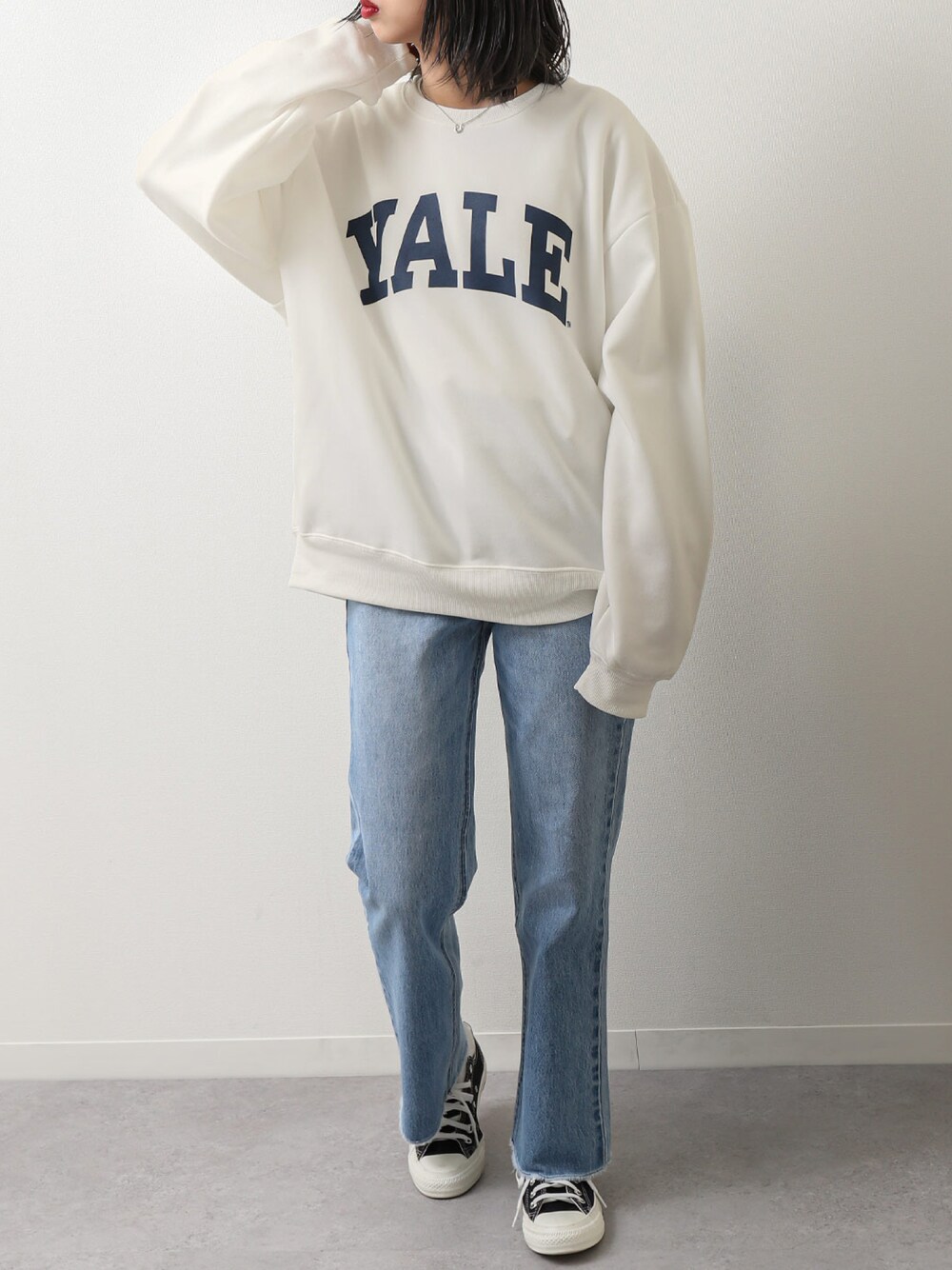 ホワイト系のスウェット、ブルー系のデニムパンツ、ブラック系のスニーカーを着用したレディースの春コーディネートの1枚目の写真