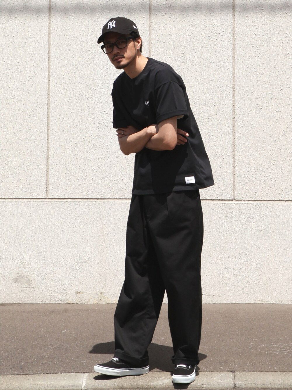 ブラック系のチノパンツ、ブラック系のスニーカー、ブラック系のTシャツ/カットソーを着用したメンズの夏コーディネートの1枚目の写真