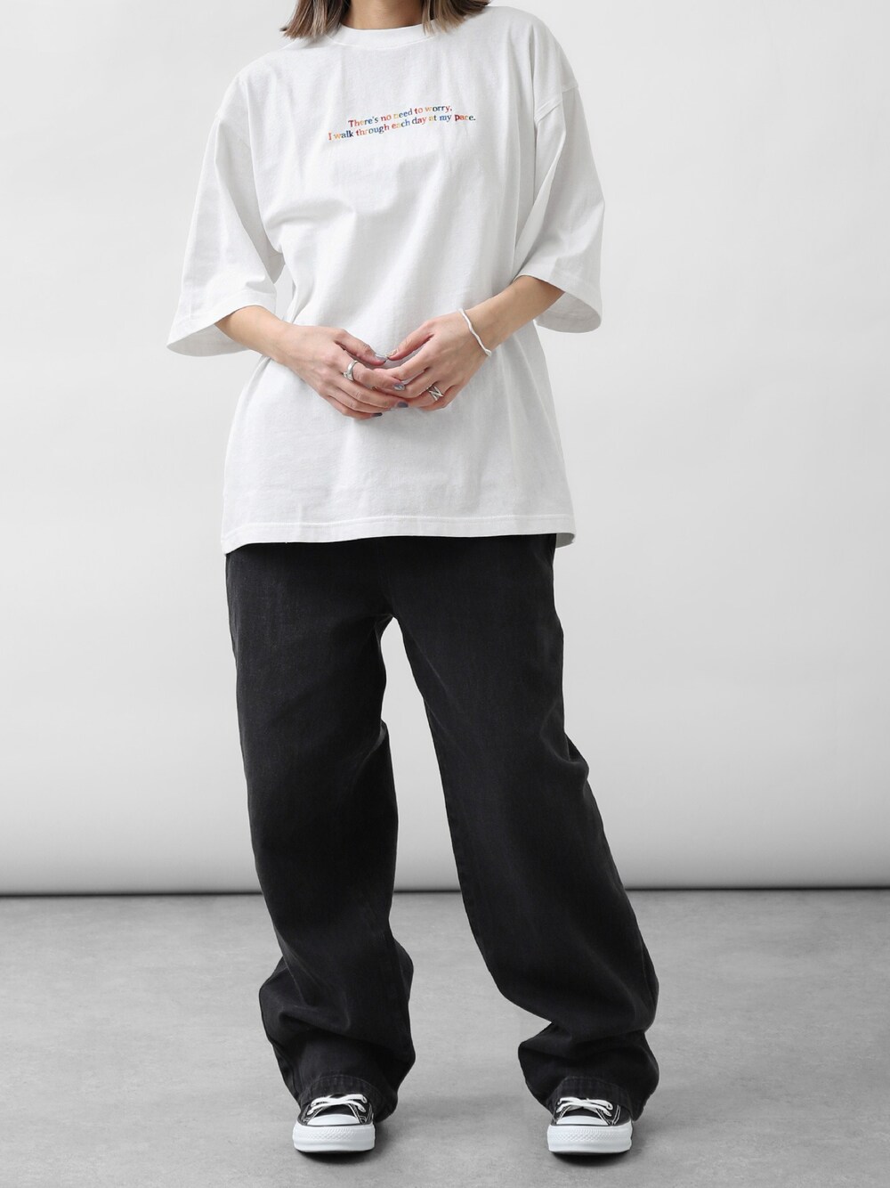 ホワイト系のTシャツ/カットソー、ブラック系のデニムパンツ、ブラック系のスニーカーを着用したレディースの春コーディネートの1枚目の写真