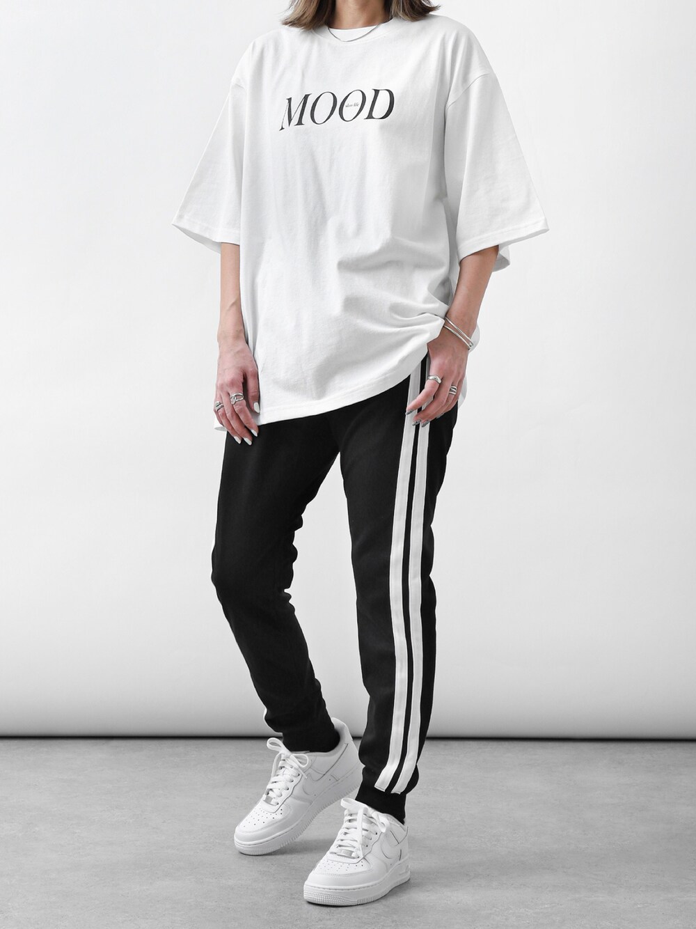 ホワイト系のTシャツ/カットソー、ブラック系のその他パンツ、ホワイト系のスニーカーを着用したレディースの春コーディネートの1枚目の写真