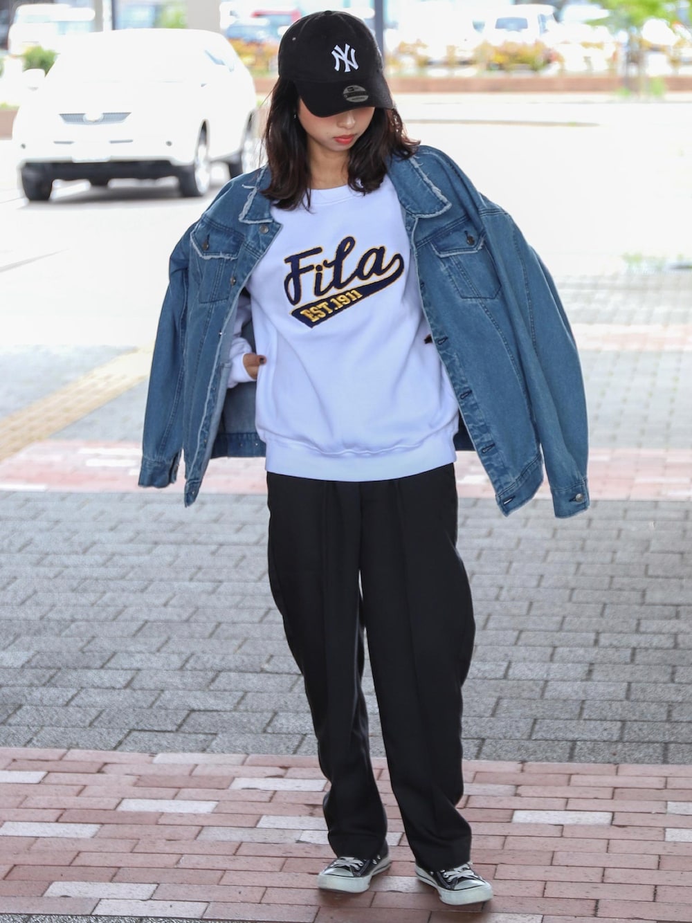 ホワイト系のスウェット、ブラック系のスラックス、ブラック系のスニーカーを着用したレディースの秋コーディネートの1枚目の写真