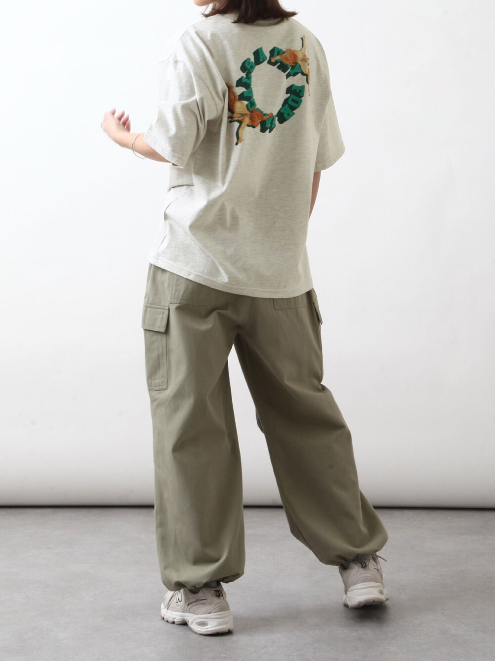 ベージュ系のTシャツ/カットソー、グリーン系のカーゴパンツ、ベージュ系のスニーカーを着用したレディースの春コーディネートの1枚目の写真