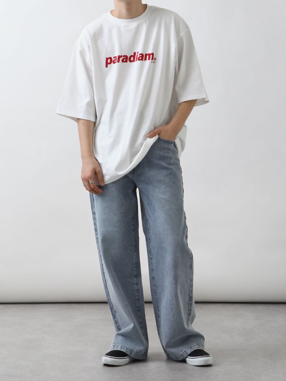 ホワイト系のTシャツ/カットソー、ブルー系のデニムパンツ、ブラック系のスニーカーを着用したメンズの春コーディネートの1枚目の写真