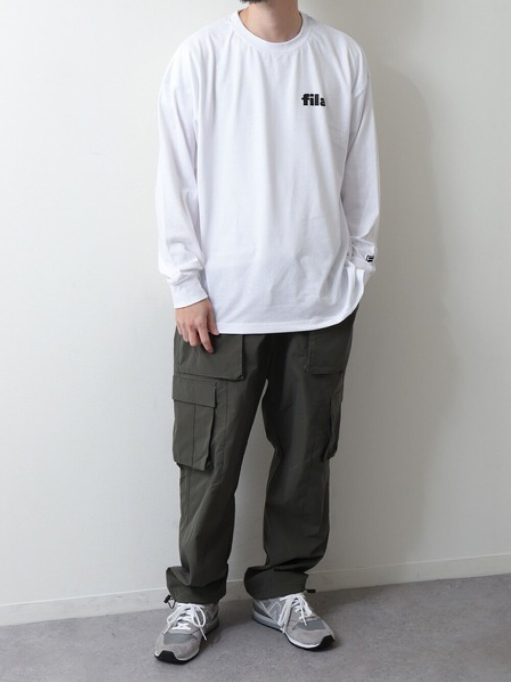 ホワイト系のTシャツ/カットソー、グリーン系のカーゴパンツ、グレー系のスニーカーを着用したメンズの春コーディネートの1枚目の写真