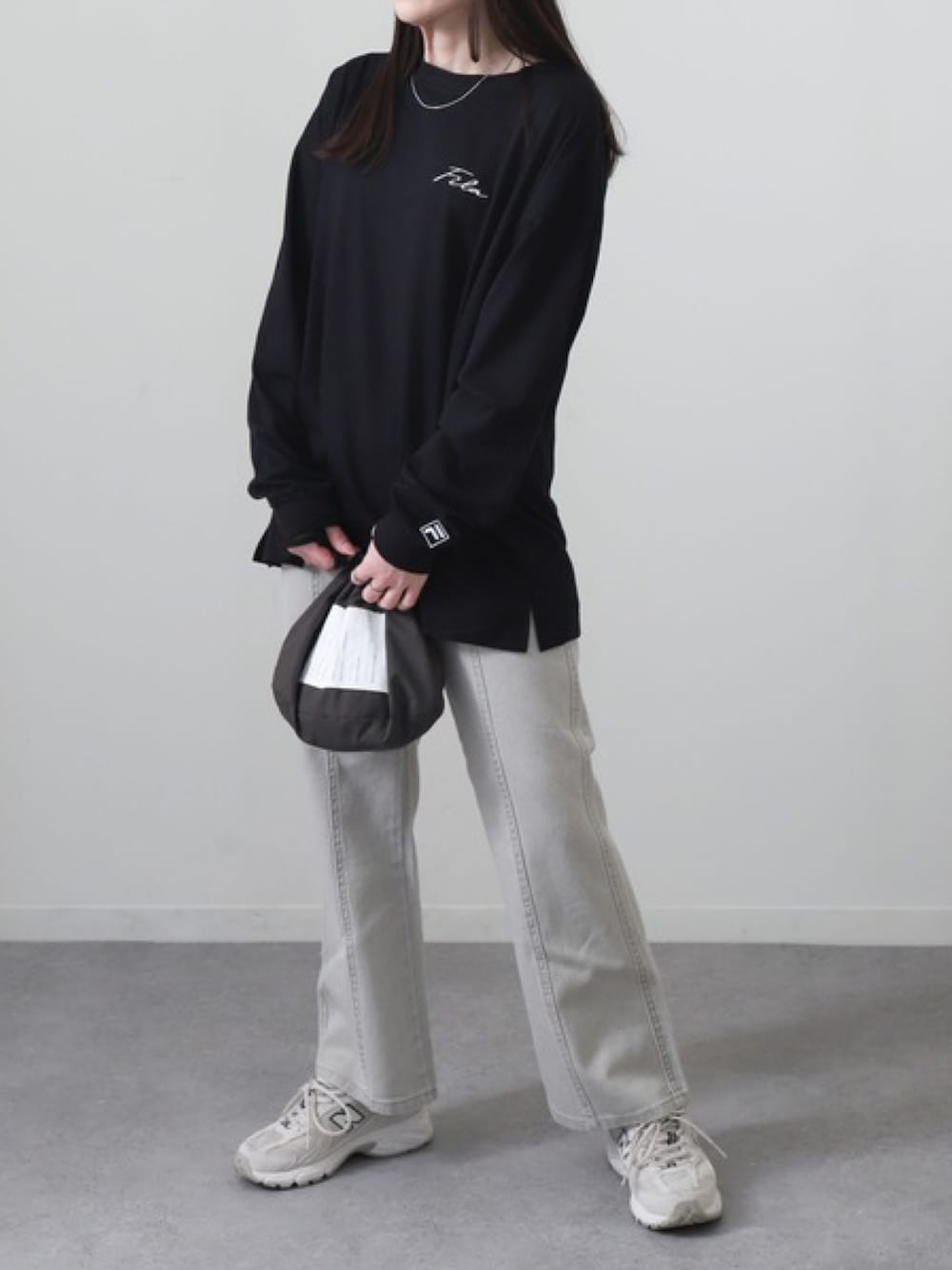 ブラック系のTシャツ/カットソー、グレー系のデニムパンツ、ベージュ系のスニーカーを着用したレディースの春コーディネートの1枚目の写真