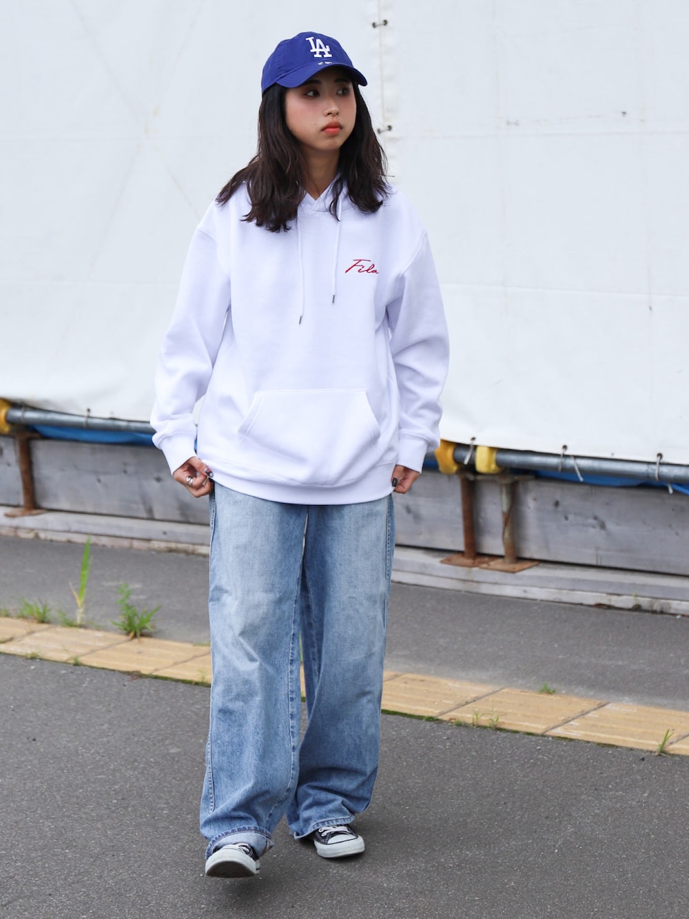 ブルー系のチノパンツ、ブラック系のスニーカー、ホワイト系のパーカーを着用したレディースの秋コーディネートの1枚目の写真