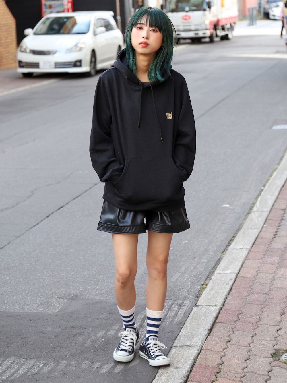 ブラック系のスニーカー、ブラック系のパーカーを着用したレディースの秋コーディネートの1枚目の写真