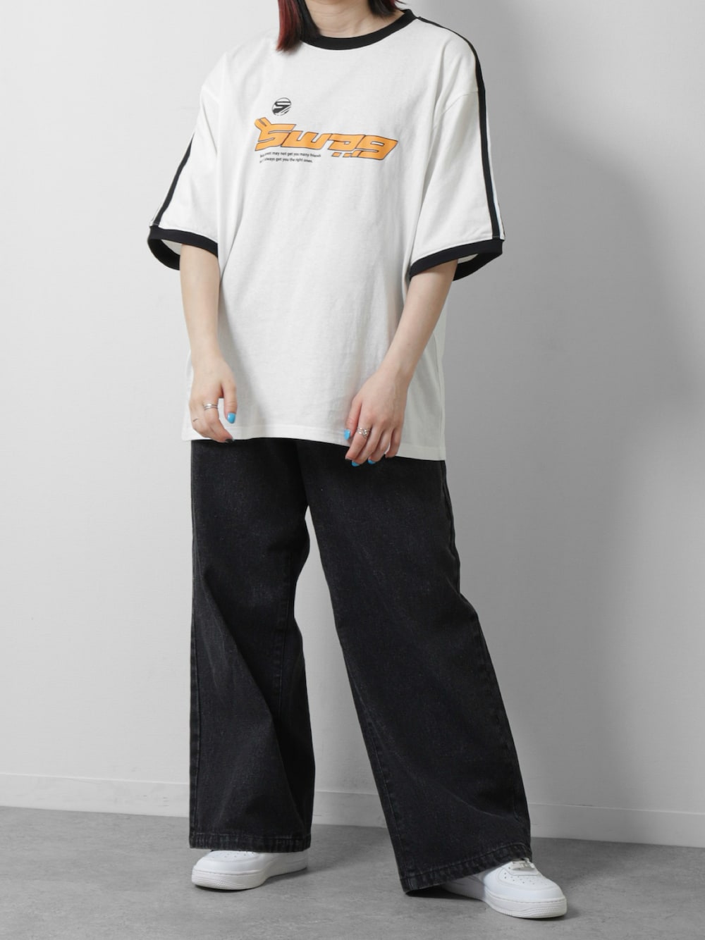 ホワイト系のTシャツ/カットソー、ブラック系のデニムパンツ、ホワイト系のスニーカーを着用したレディースの春コーディネートの1枚目の写真