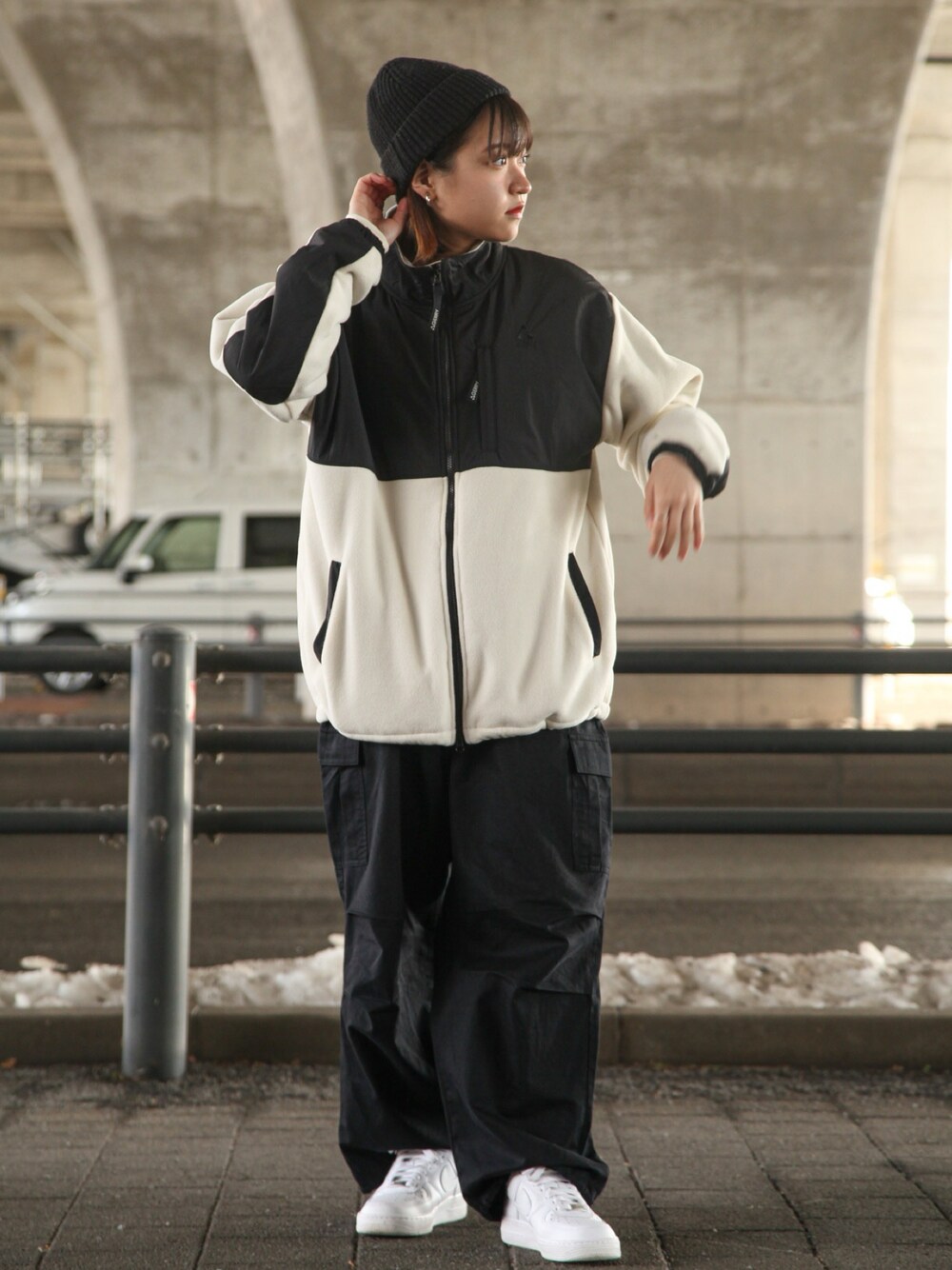 ホワイト系のブルゾン、ブラック系のカーゴパンツ、ホワイト系のスニーカーを着用したレディースの冬コーディネートの1枚目の写真