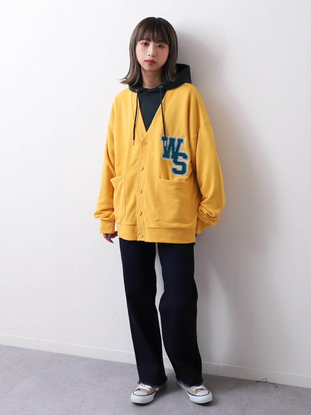 イエロー系のカーディガン/ボレロ、ブラック系のパーカー、ベージュ系のスニーカーを着用したレディースの春コーディネートの1枚目の写真