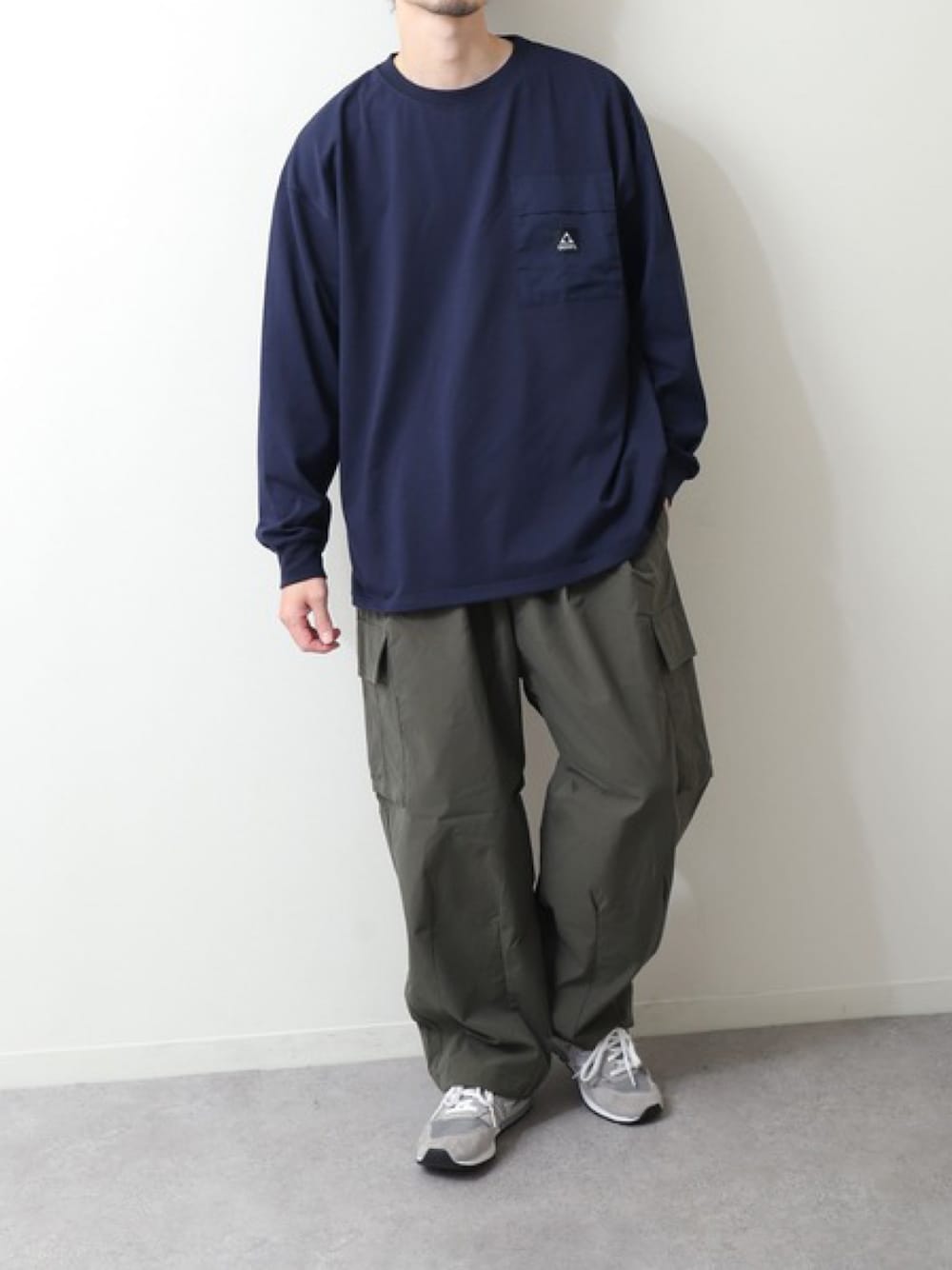 ブルー系のTシャツ/カットソー、グリーン系のカーゴパンツ、グレー系のスニーカーを着用したメンズの春コーディネートの1枚目の写真