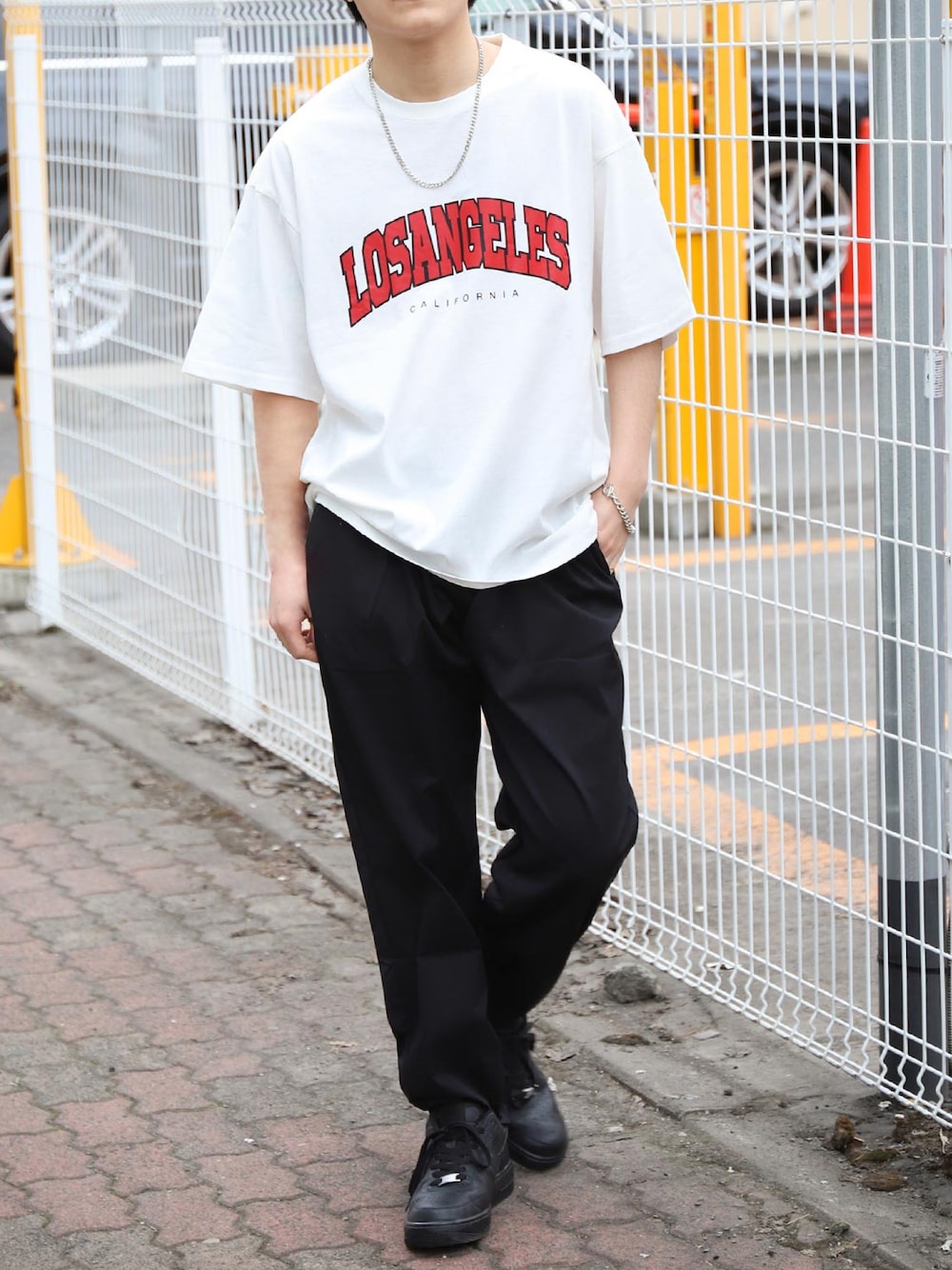 「シンプル、夏コーデ、ブラックコーデ、Tシャツ、ホワイト、ブラック、スニーカー、NIKE、NIKE AIR FORCE、ストリート、ストリートコーデ、シンプルコーデ」｜「ZIP FIVEのストリートロゴ バリエーション半袖Tシャツ　アーチ　カレッジ　バッグプリント【ユニセックス】（Tシャツ/カットソー、ホワイト系）」を使った、ZIP FIVE【Official】さん（メンズ・170cm）の春コーディネートの1枚目の写真