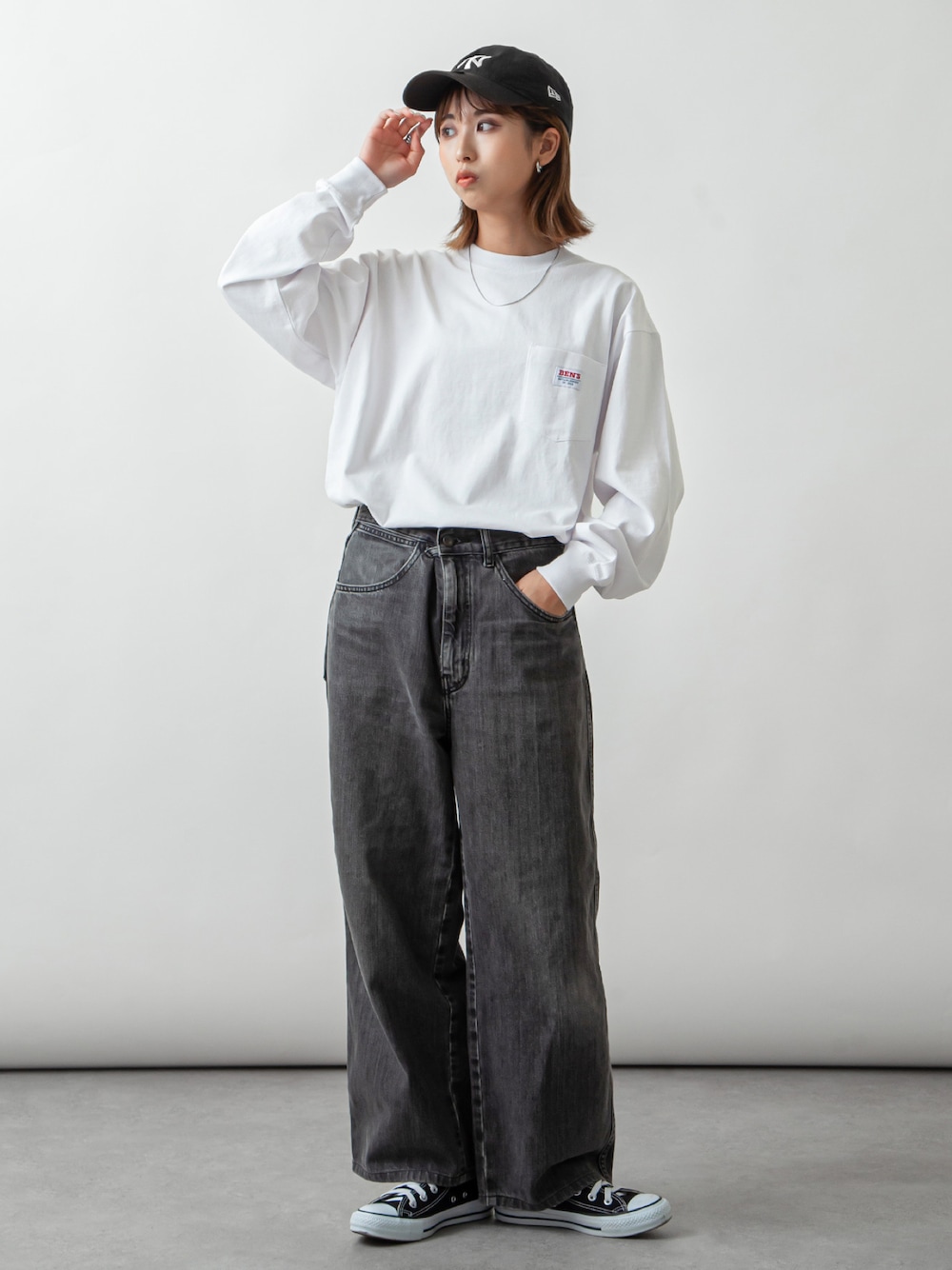 ホワイト系のTシャツ/カットソー、グレー系のデニムパンツ、ブラック系のスニーカーを着用したレディースの秋コーディネートの1枚目の写真