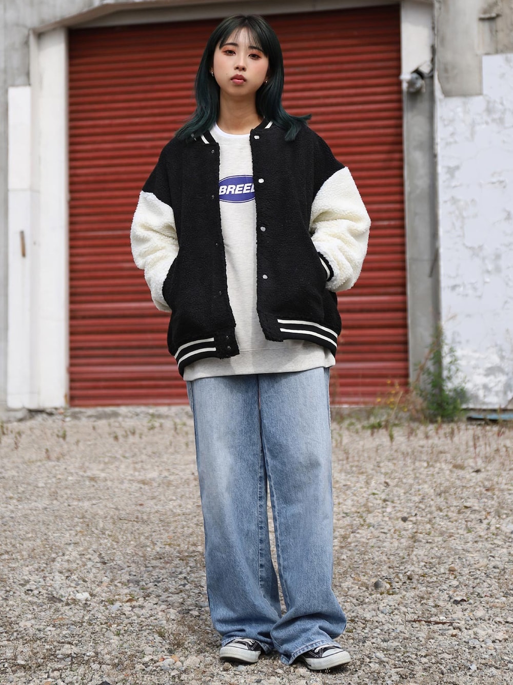 ブラック系のスタジャン、ホワイト系のスウェット、ブラック系のスニーカーを着用したレディースの冬コーディネートの1枚目の写真