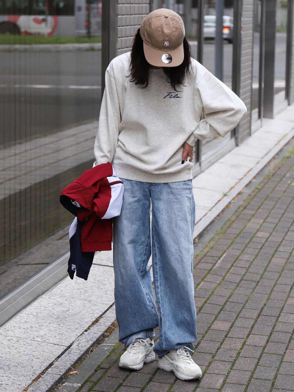 ベージュ系のスウェット、ブルー系のチノパンツ、ベージュ系のスニーカーを着用したレディースの秋コーディネートの1枚目の写真