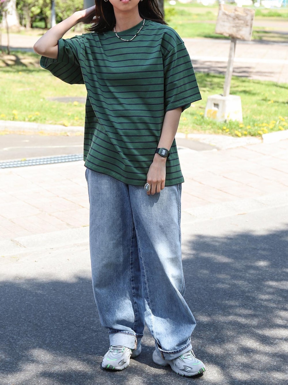 グリーン系のTシャツ/カットソー、ブルー系のチノパンツ、グレー系のスニーカーを着用したレディースの夏コーディネートの1枚目の写真