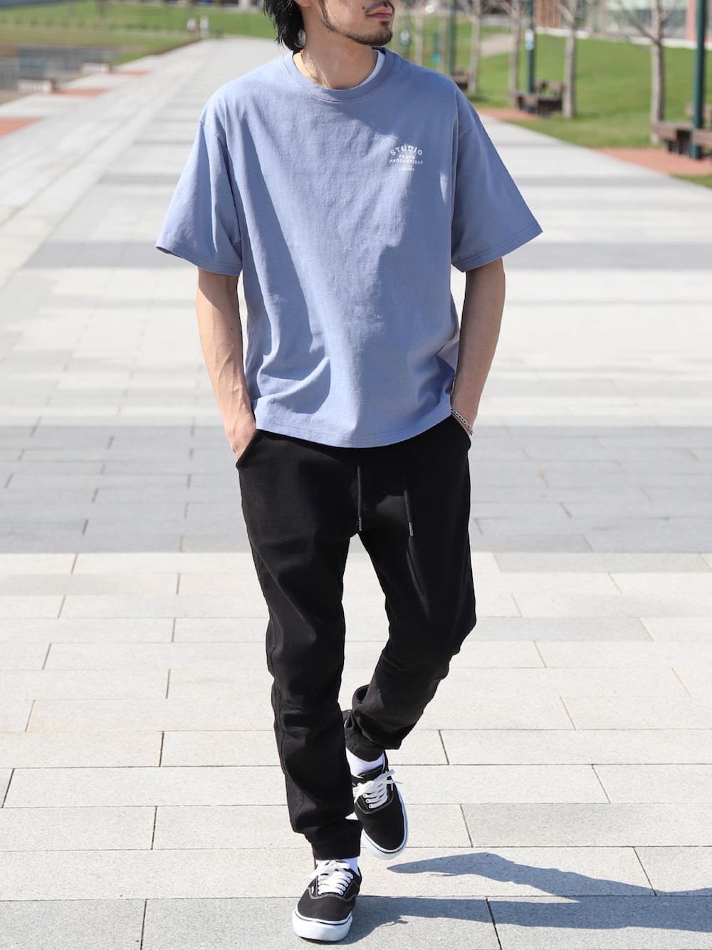 ブルー系のTシャツ/カットソー、ブラック系のチノパンツ、ブラック系のスニーカーを着用したメンズの夏コーディネートの1枚目の写真