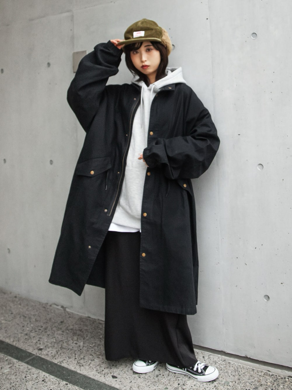 ブラック系のモッズコート、グレー系のパーカー、ブラック系のスニーカーを着用したレディースの冬コーディネートの1枚目の写真