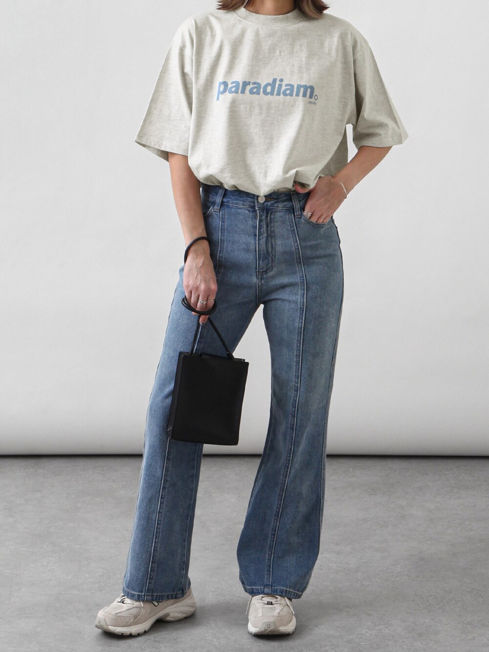 ベージュ系のTシャツ/カットソー、ベージュ系のスニーカー、ブルー系のデニムパンツを着用したレディースの春コーディネートの1枚目の写真