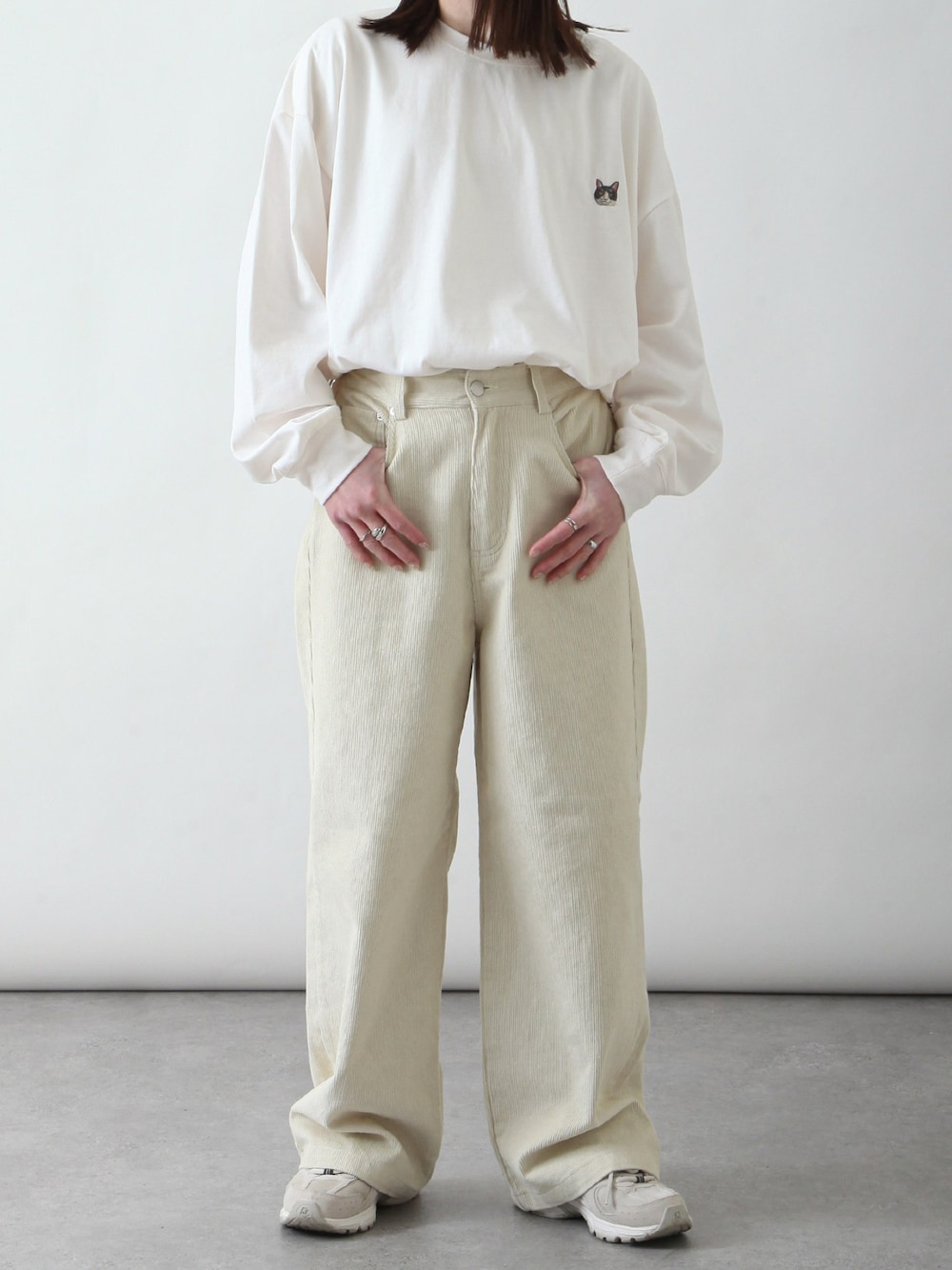 ホワイト系のTシャツ/カットソー、ホワイト系のチノパンツ、ベージュ系のスニーカーを着用したレディースの春コーディネートの1枚目の写真