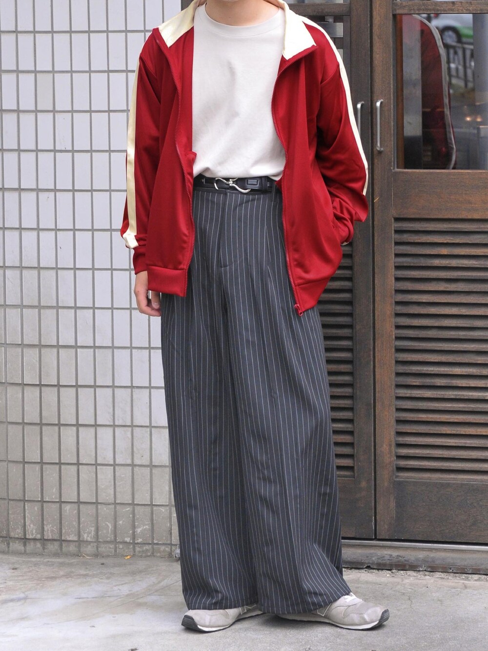 レッド系のジャージ、ベージュ系のTシャツ/カットソー、グレー系のスニーカーを着用したメンズの秋コーディネートの1枚目の写真