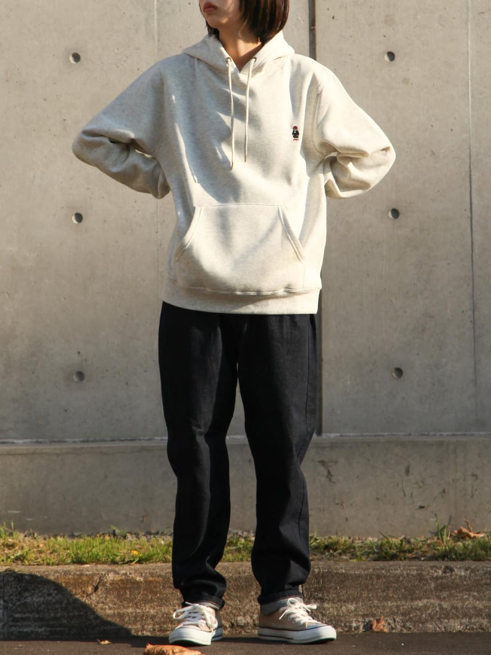 ベージュ系のパーカー、ブラック系のチノパンツ、ベージュ系のスニーカーを着用したレディースの秋コーディネートの1枚目の写真