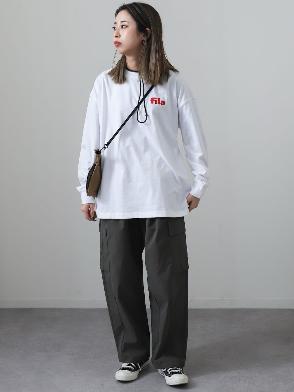 ホワイト系のTシャツ/カットソー、グレー系のカーゴパンツ、ブラック系のスニーカーを着用したレディースの春コーディネートの1枚目の写真