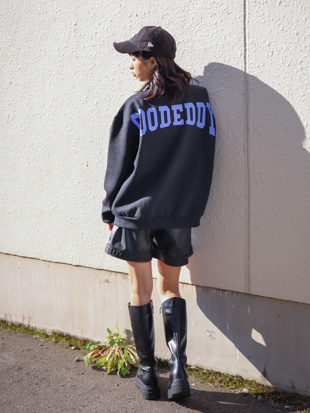 ブラック系のスウェット、ブルー系のキャップを着用したレディースの秋コーディネートの1枚目の写真