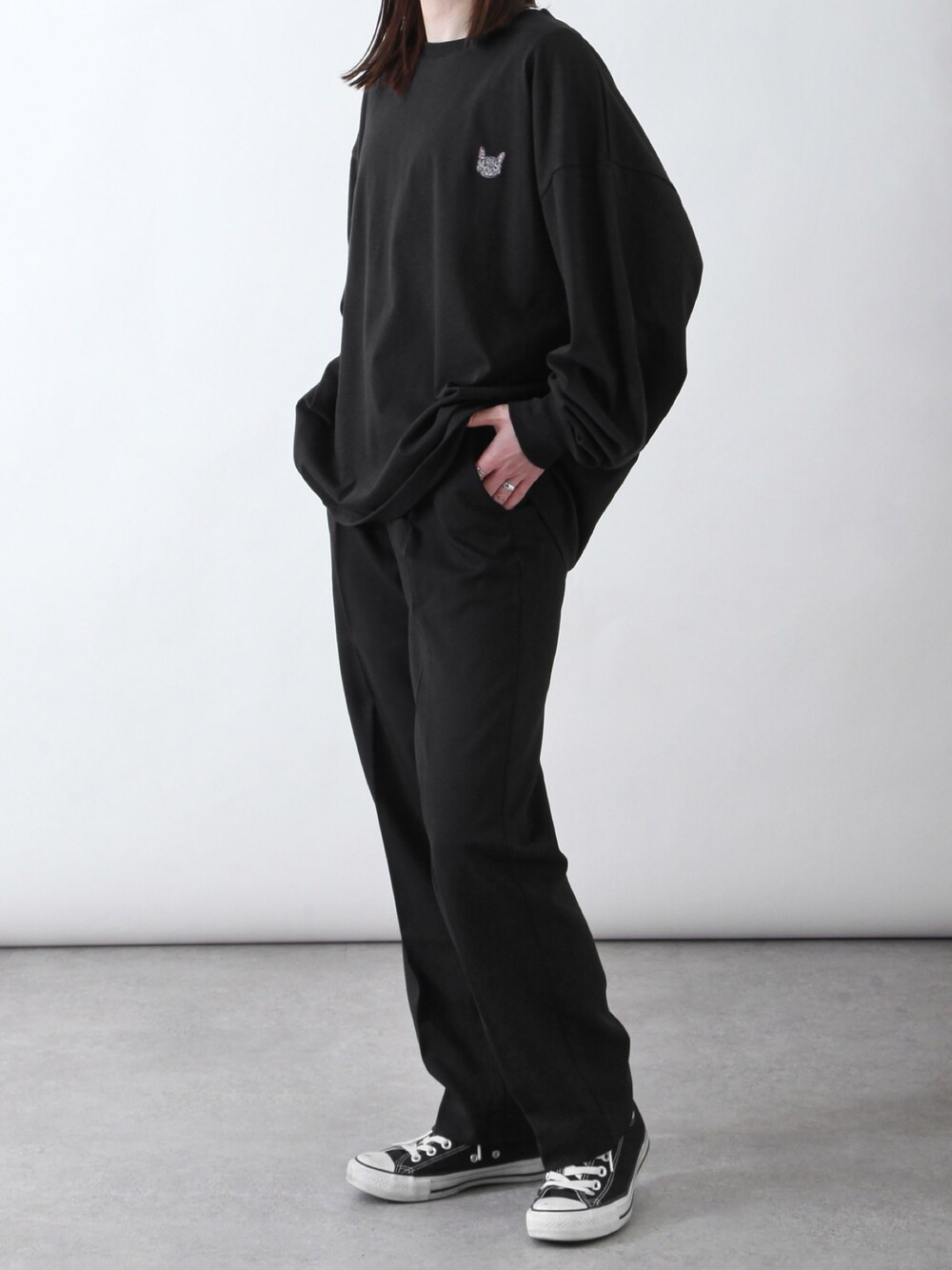 ブラック系のTシャツ/カットソー、ブラック系のスラックス、ブラック系のスニーカーを着用したレディースの春コーディネートの1枚目の写真