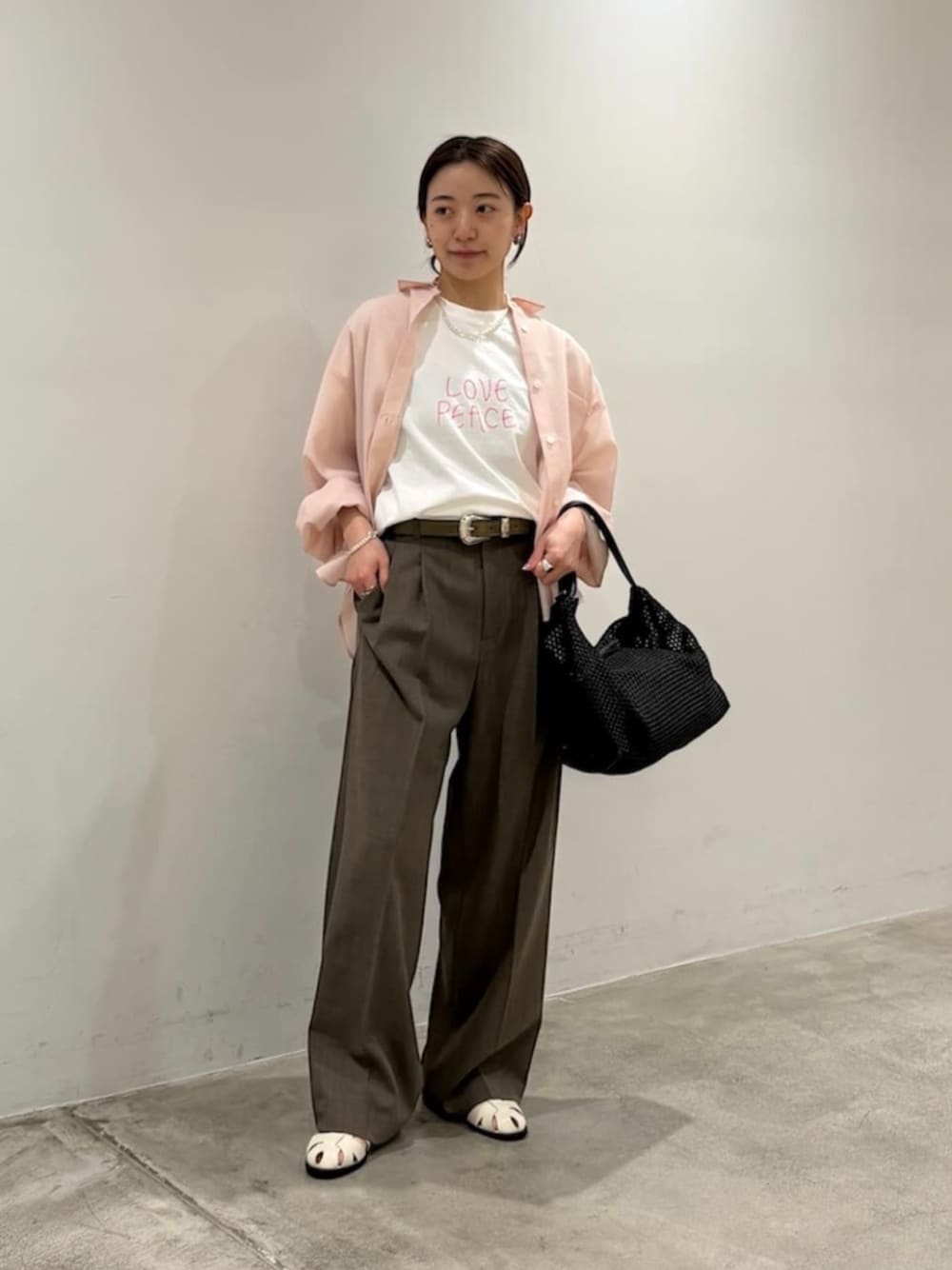 ブラウン系のその他パンツ、ホワイト系のサンダル、ブラック系のショルダーバッグを着用したレディースの春コーディネートの1枚目の写真