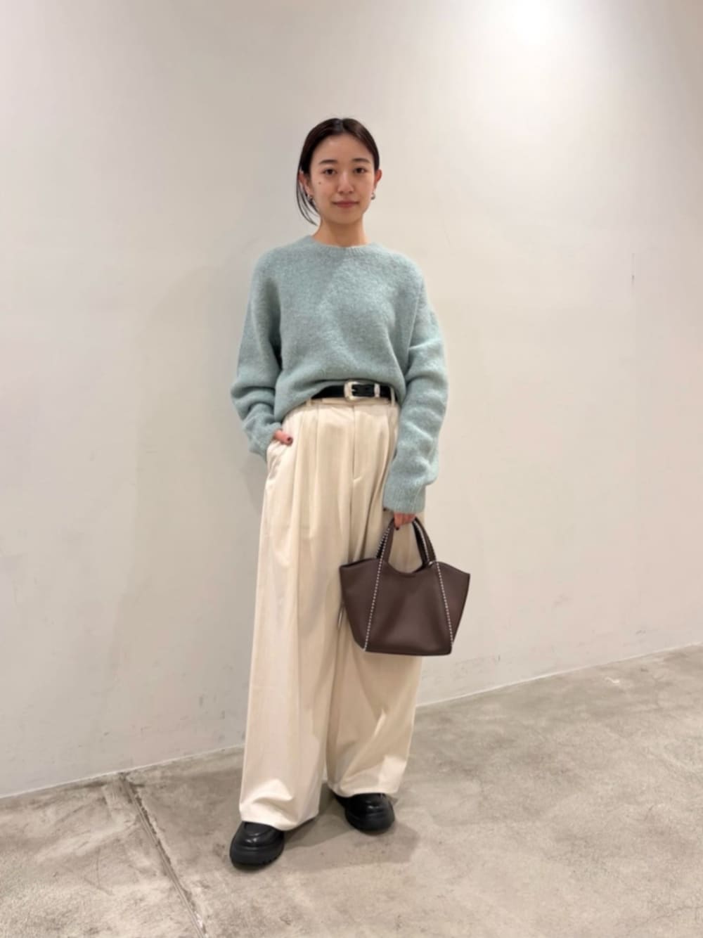 ホワイト系のその他パンツ、ブラック系のローファー、グリーン系のニット/セーターを着用したレディースの冬コーディネートの1枚目の写真