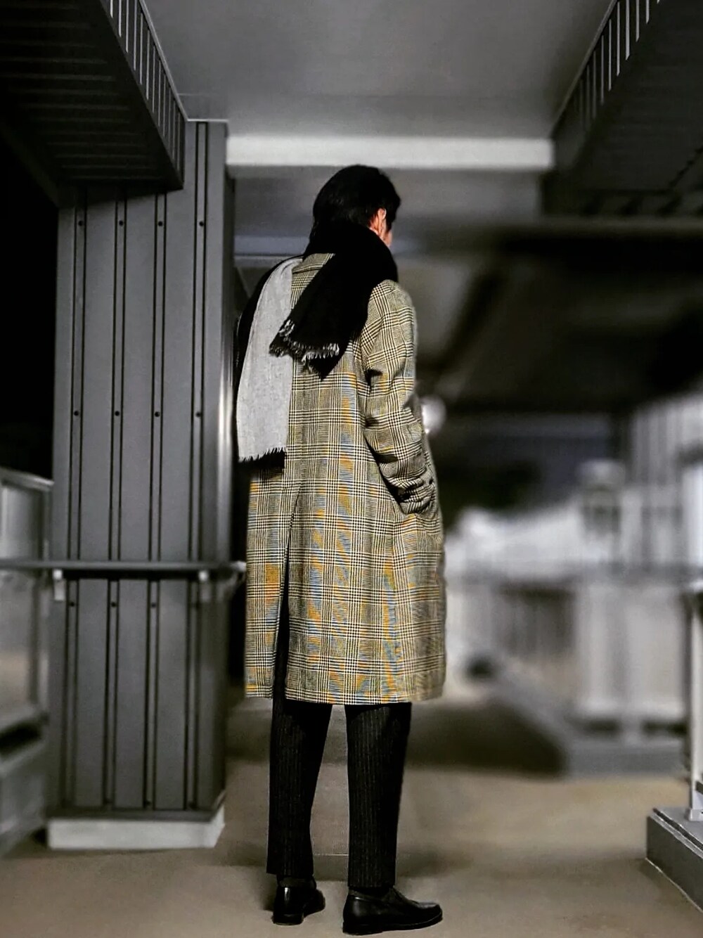 グレー系のスラックス、ブラック系のドレスシューズ、グレー系のステンカラーコートを着用したメンズの春コーディネートの5枚目の写真