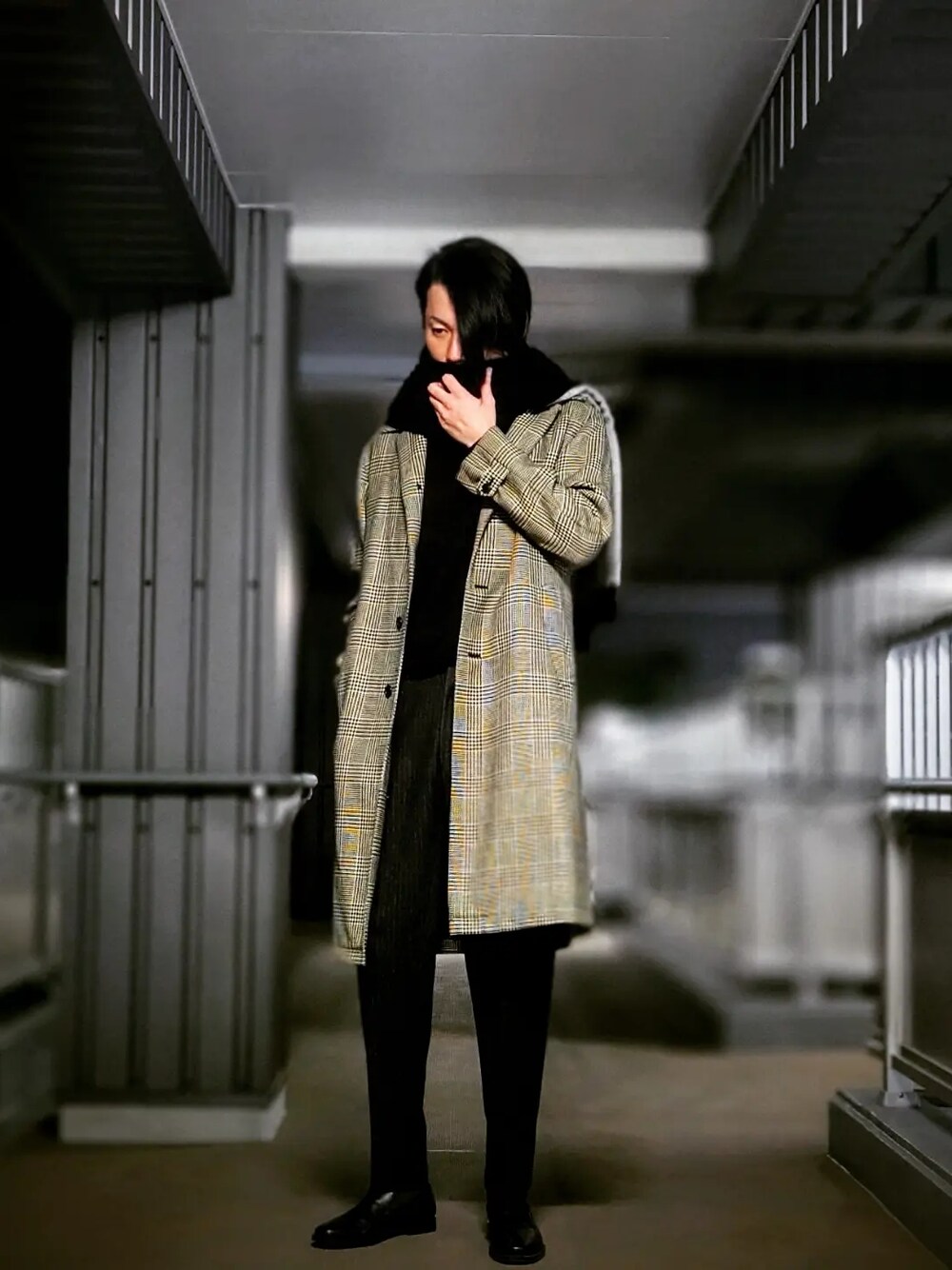 グレー系のスラックス、ブラック系のドレスシューズ、グレー系のステンカラーコートを着用したメンズの春コーディネートの3枚目の写真