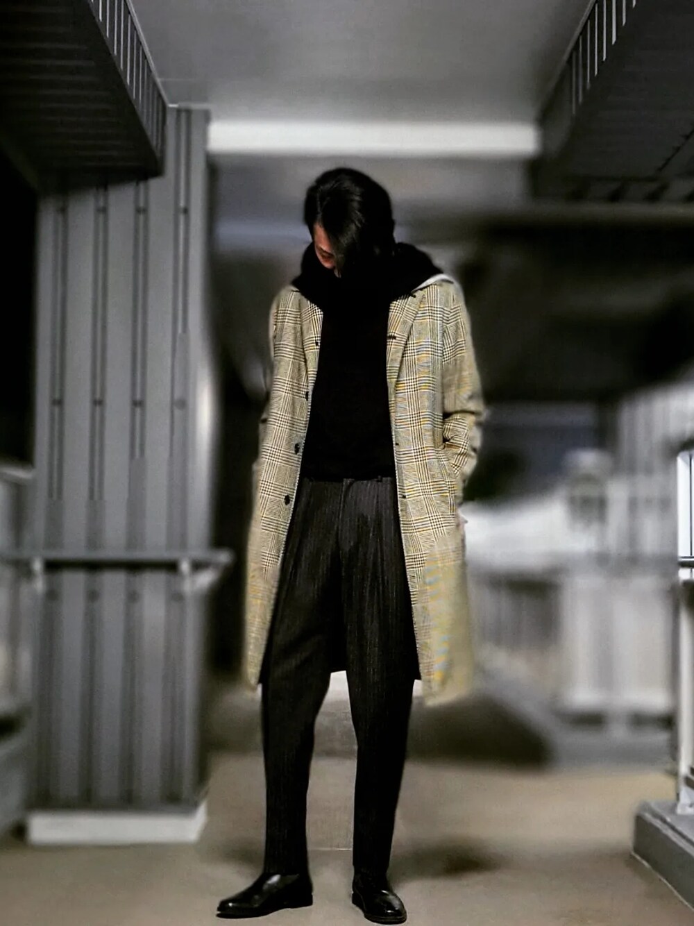 グレー系のスラックス、ブラック系のドレスシューズ、グレー系のステンカラーコートを着用したメンズの春コーディネートの4枚目の写真