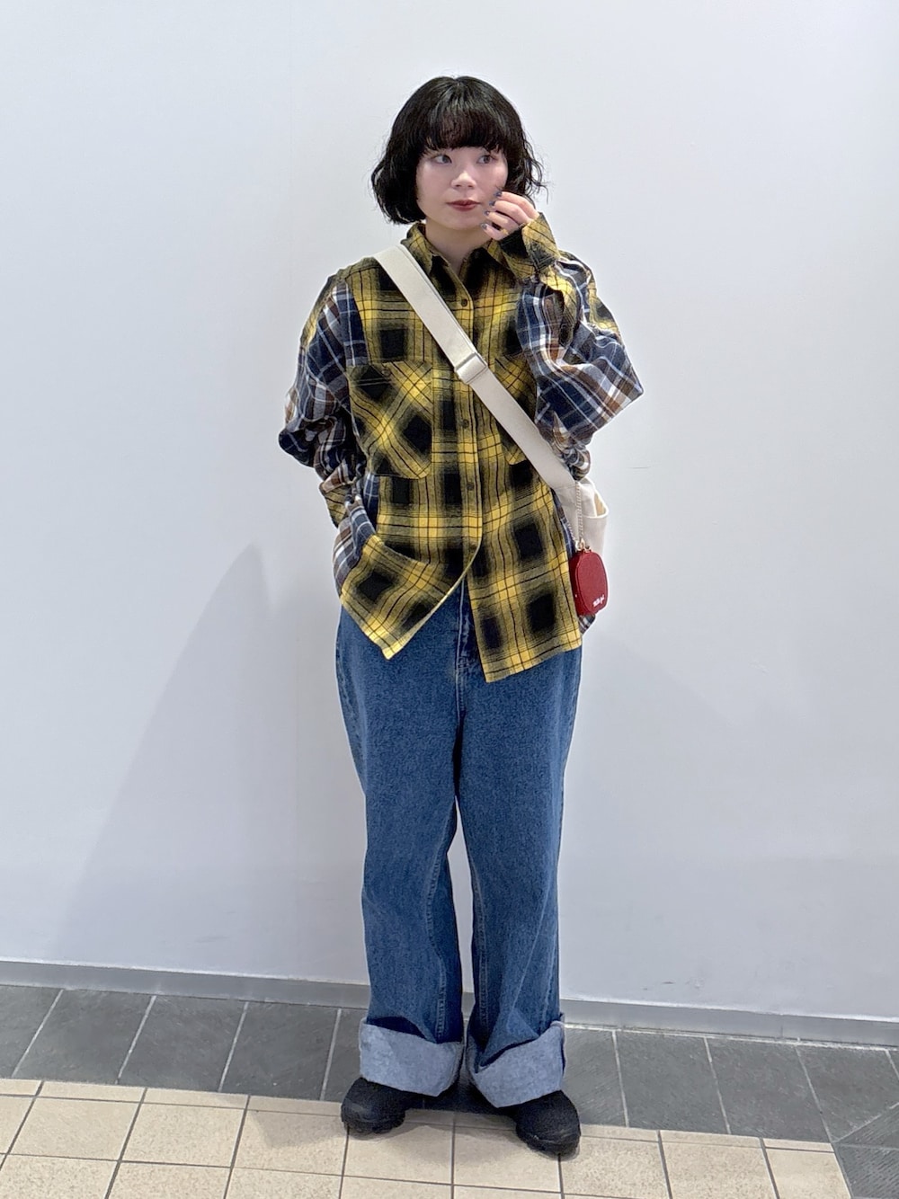 イエロー系のシャツ/ブラウス、ブルー系のデニムパンツ、その他のトートバッグを着用したレディースの冬コーディネートの1枚目の写真