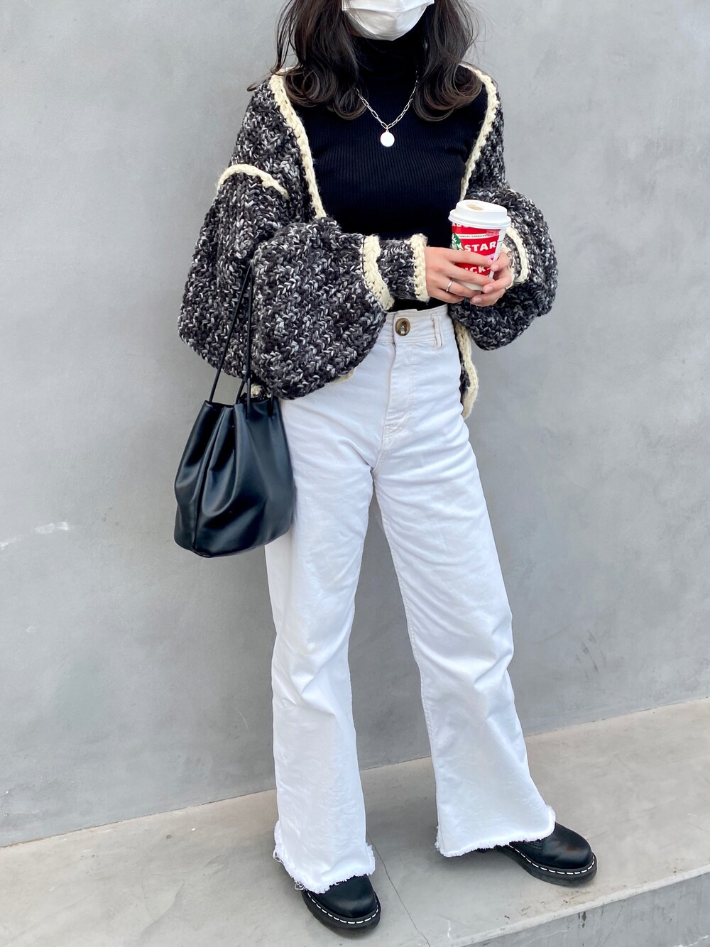 ホワイト系のパンツ、ブラック系のニット/セーター、ブラック系のブーツを着用したレディースの秋コーディネートの1枚目の写真