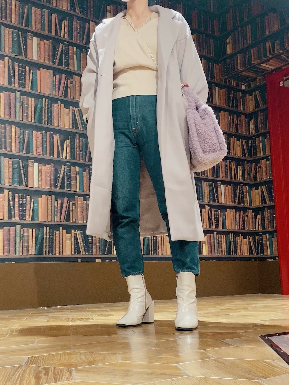 ホワイト系のニット/セーター、ブルー系のデニムパンツ、ホワイト系のブーツを着用したレディースの冬コーディネートの1枚目の写真
