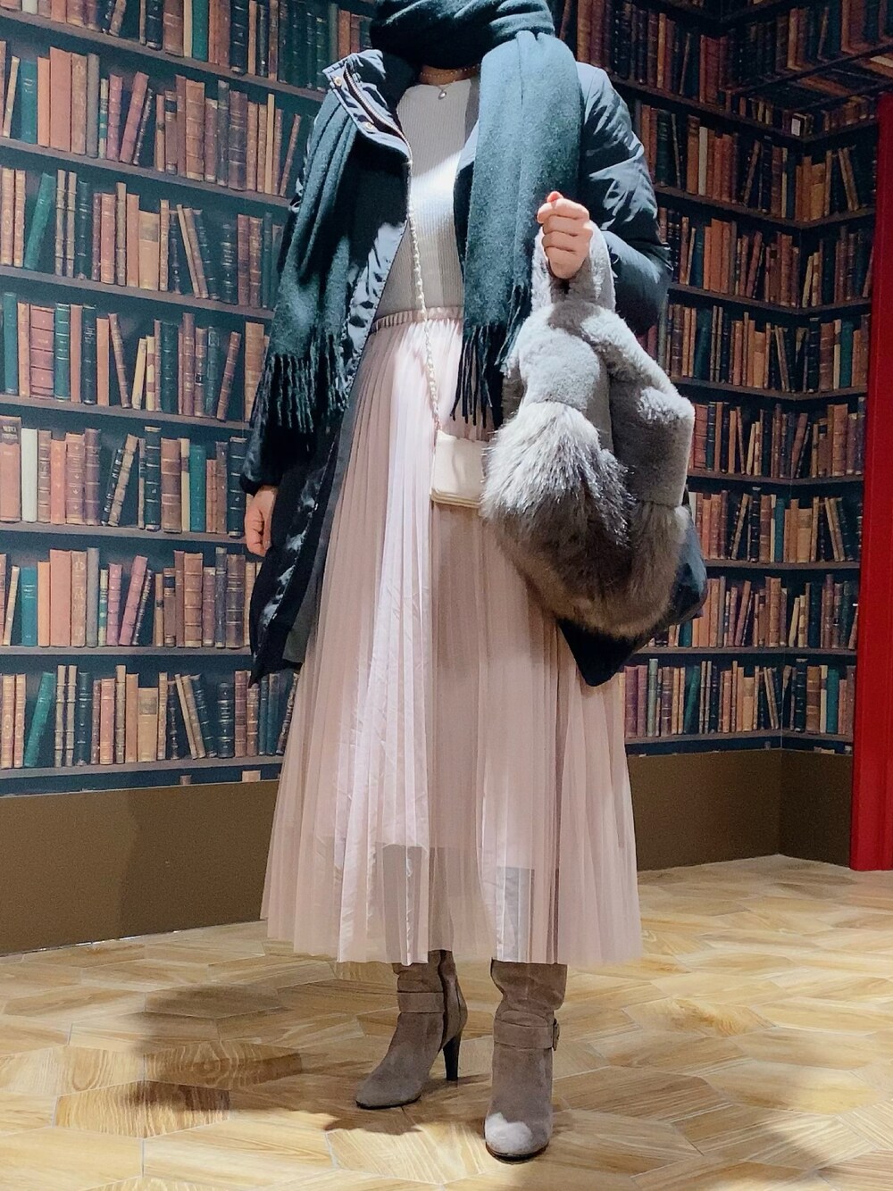 ピンク系のスカート、グレー系のブーツ、グレー系のハンドバッグを着用したレディースの冬コーディネートの1枚目の写真