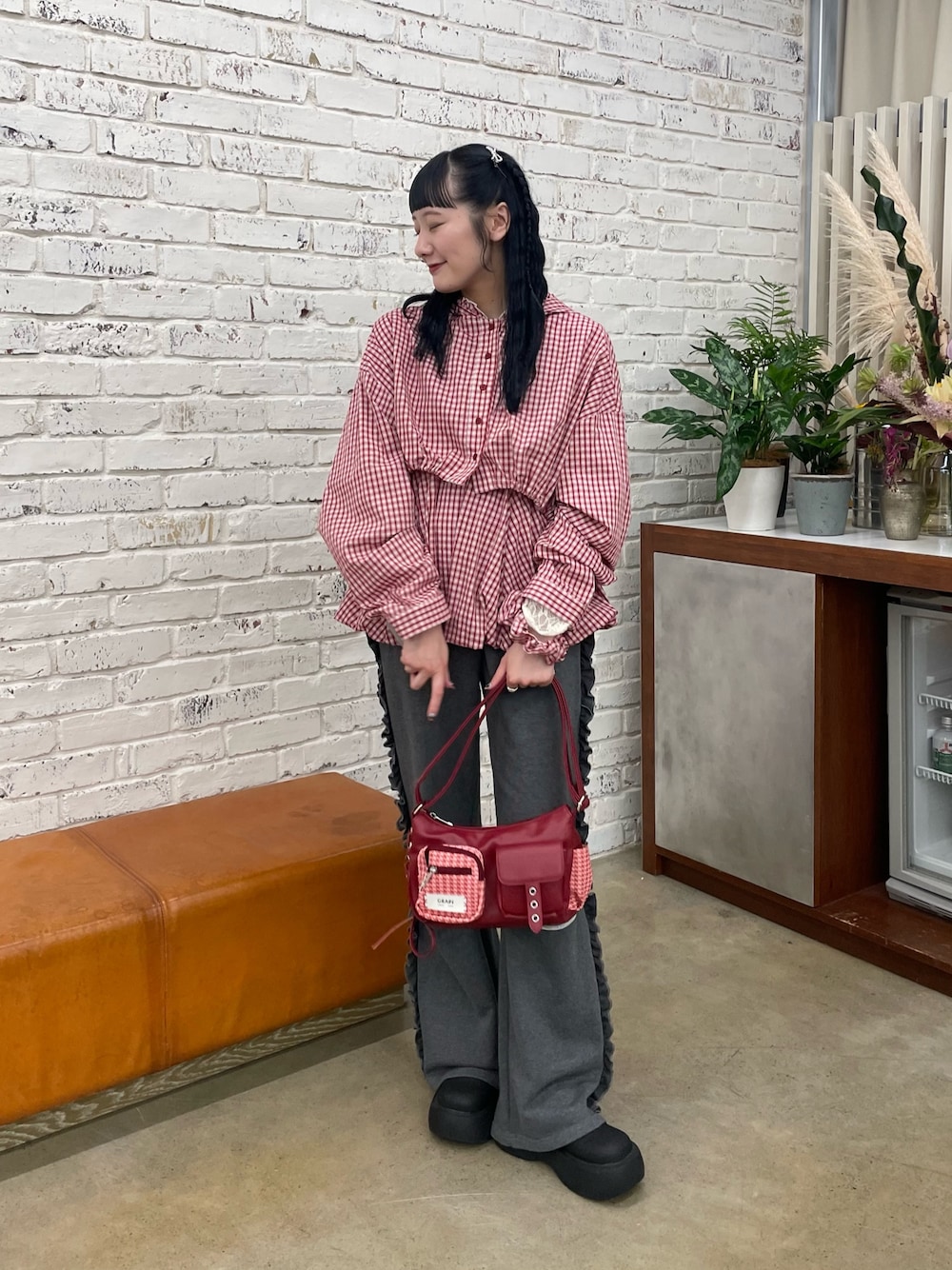 レッド系のシャツ/ブラウス、レッド系のショルダーバッグ、ブラック系のサンダルを着用したレディースの秋コーディネートの1枚目の写真