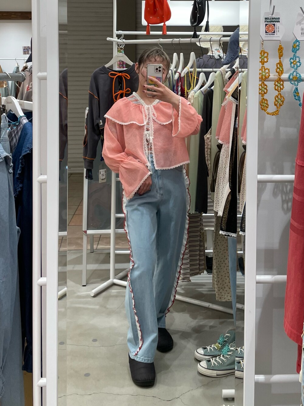 ピンク系のシャツ/ブラウス、レッド系のTシャツ/カットソー、ブルー系のデニムパンツを着用したレディースの春コーディネートの1枚目の写真