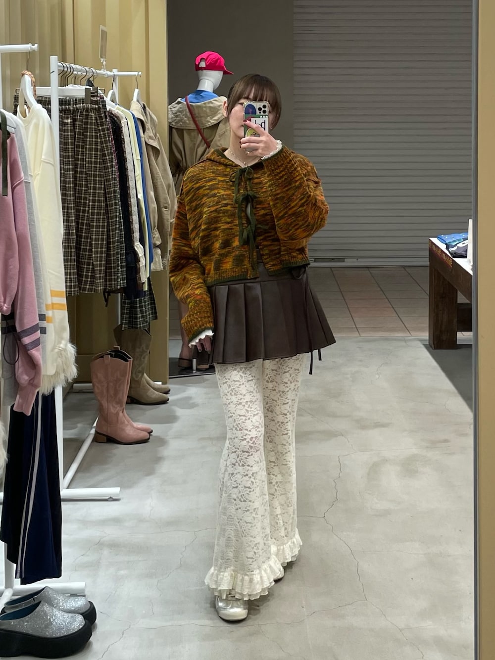 グリーン系のカーディガン/ボレロ、ブラウン系のスカート、ホワイト系のその他パンツを着用したレディースの秋コーディネートの1枚目の写真